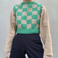 a woman wearing a green and tan sweater